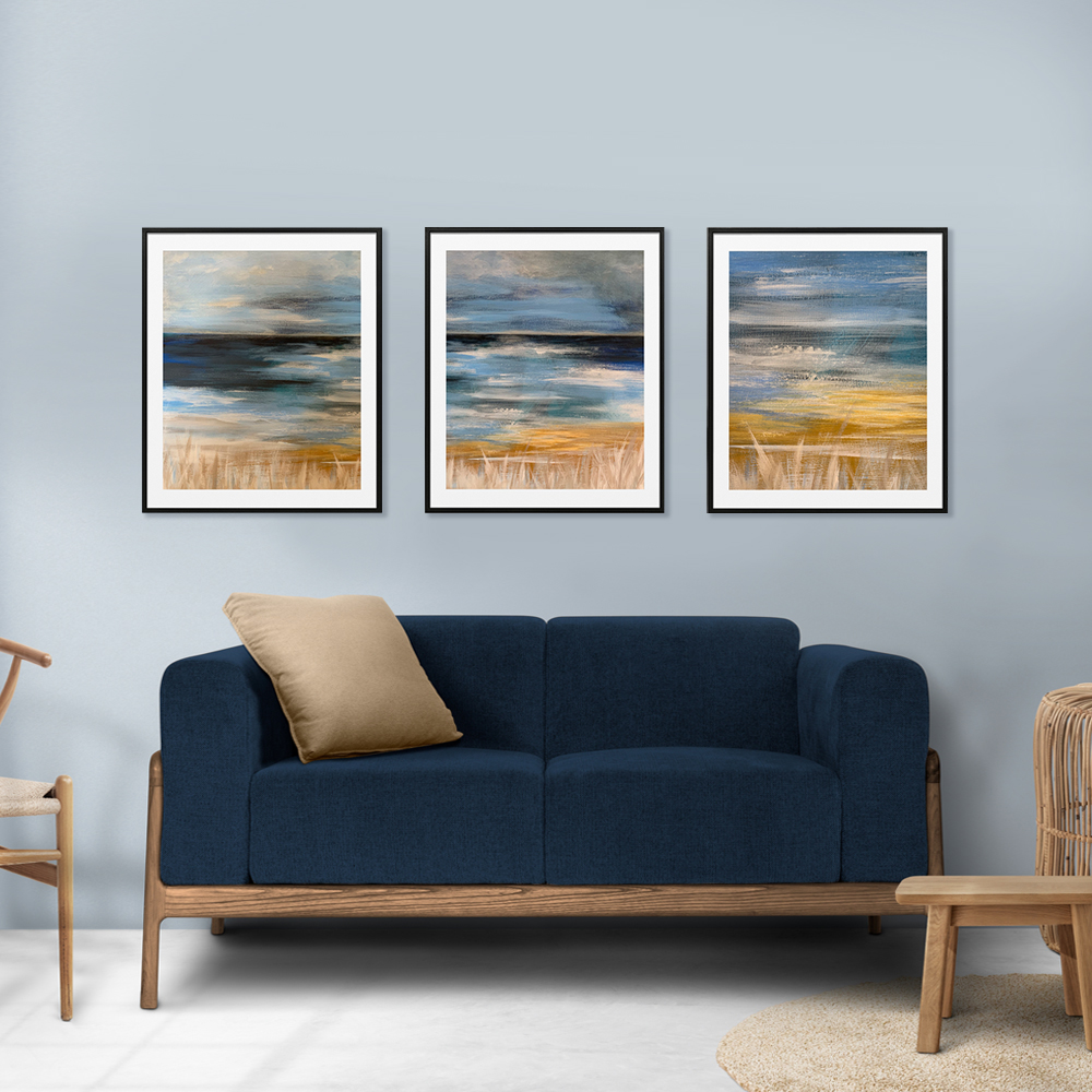 3 moody seascape prints over rustic sofa